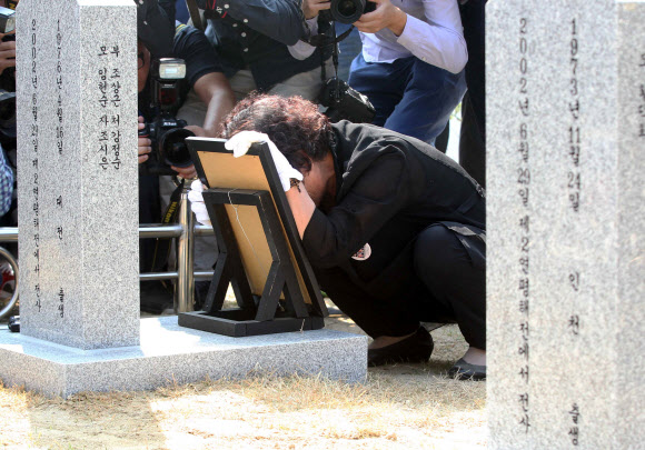 21일 대전 유성구 국립대전현충원 ‘제2연평해전 전사자 묘역’에서 조천형 중사의 유족이 오열하고 있다. 국가보훈처는 유족 합의에 따라 그동안 나뉘어 안장돼 있었던 6용사의 합동묘역을 새로 조성했다. 전사한지 13년 만이다.  연합뉴스
