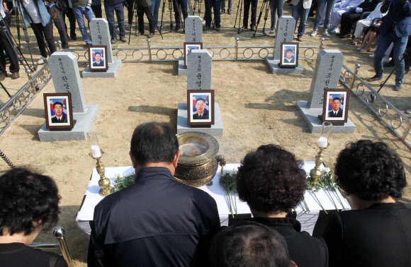 21일 대전 유성구 국립대전현충원 ‘제2연평해전 전사자 묘역’에서 유족이 묵념하고 있다. 국가보훈처는 유족 합의에 따라 그동안 나뉘어 안장돼 있었던 6용사의 합동묘역을 새로 조성했다. 전사한지 13년 만이다. 연합뉴스