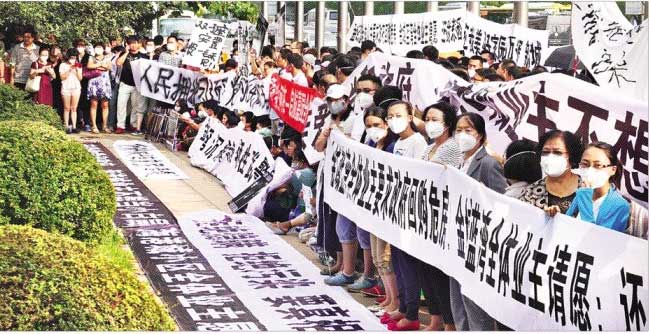 톈진 폭발 사고로 집을 잃은 시민들이 정부의 대책을 촉구하는 글이 적힌 펼침막을 든 채 시위를 하고 있다. 월스트리트저널 홈페이지 캡처
