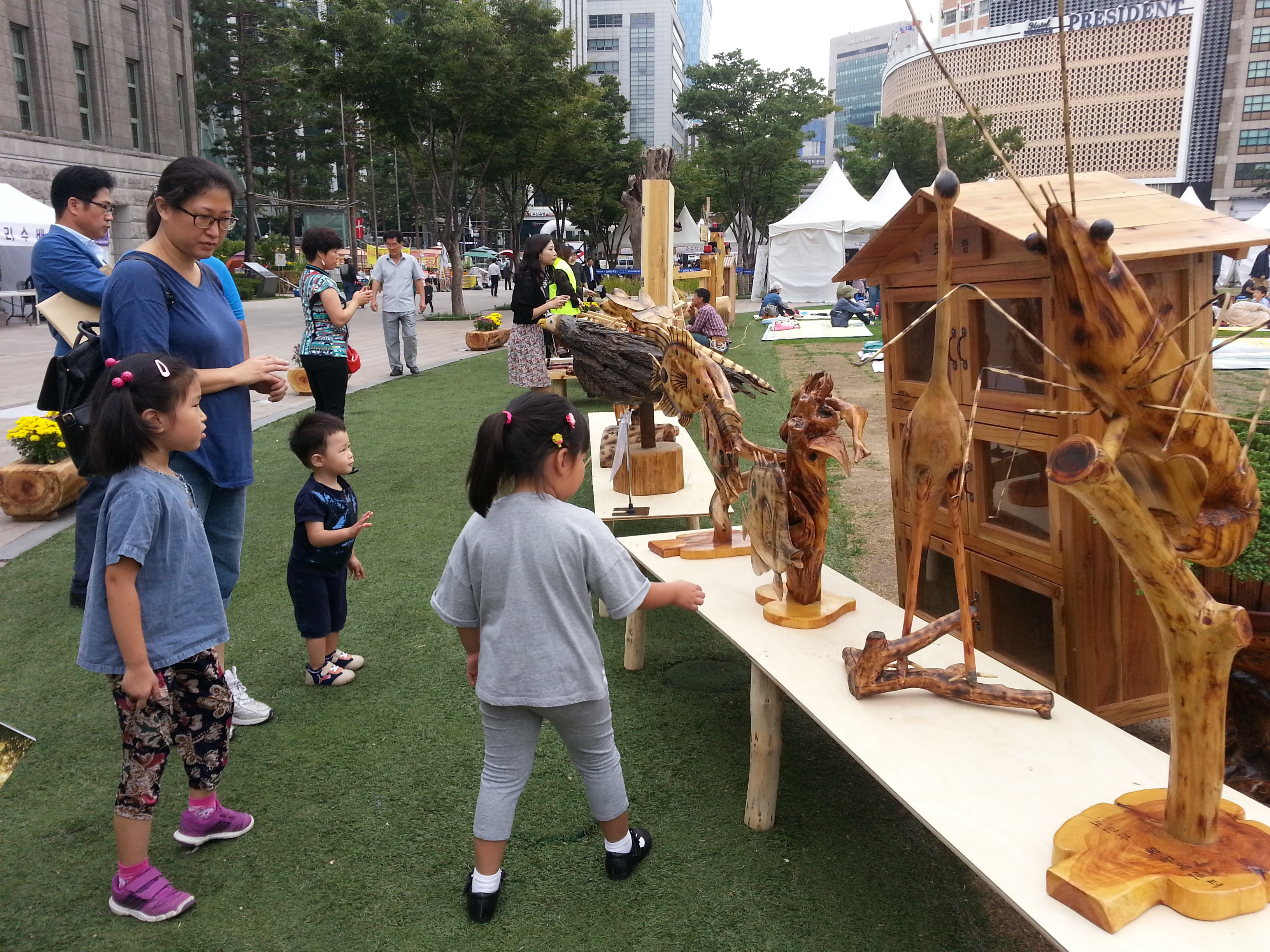 서울광장을 찾은 어린이들이 목공예품들을 신기한 듯 바라보고 있다.
