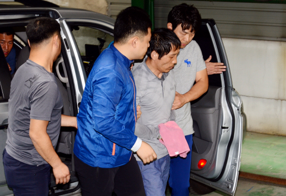 23일 오전 서울 성동구 홍익동 한 빌라 주차장에서 실시된 트렁크 시신 사건 현장 검증에서 피의자 김일곤이 차량에 불을 지르고 도주까지 범행을 재연하고 있다. 강성남 선임기자 snk@seoul.co.kr