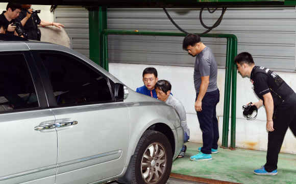 23일 오전 서울 성동구 홍익동 한 빌라 주차장에서 실시된 트렁크 시신 사건 현장 검증에서 피의자 김일곤이 차량에 불을 지르고 도주까지 범행을 재연하고 있다.  강성남 선임기자 snk@seoul.co.kr