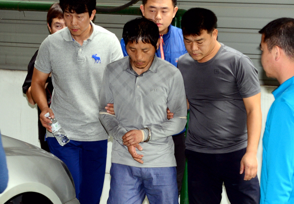 23일 오전 서울 성동구 홍익동 한 빌라 주차장에서 실시된 트렁크 시신 사건 현장 검증에서 피의자 김일곤이 차량에 불을 지르고 도주까지 범행을 재연하고 있다. 강성남 선임기자 snk@seoul.co.kr