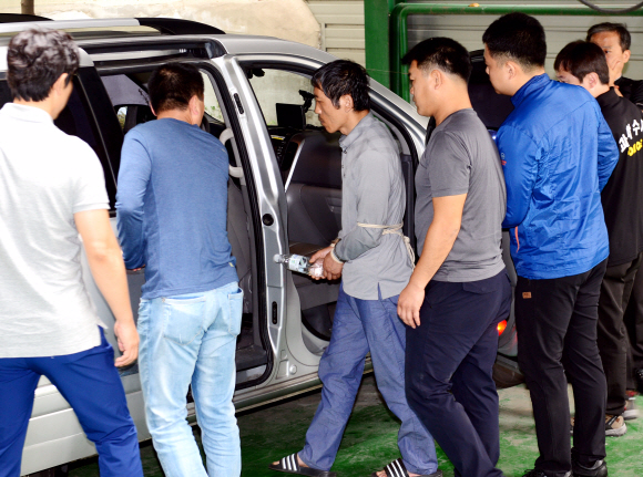 23일 오전 서울 성동구 홍익동 한 빌라 주차장에서 실시된 트렁크 시신 사건 현장 검증에서 피의자 김일곤이 차량에 불을 지르고 도주까지 범행을 재연하고 있다. 강성남 선임기자 snk@seoul.co.kr