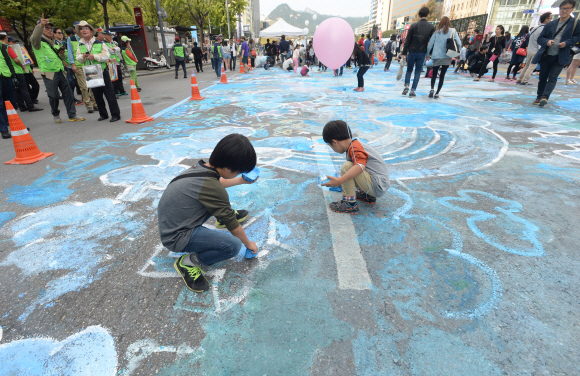 하이서울페스티벌 마지막날인 4일 서울 세종대로에서 시민들이 아스팔트 도로 위에 분필과 수성 물감으로 그림을 그리고 있다.  손형준 기자 boltagoo@seoul.co.kr