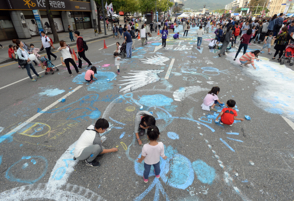 하이서울페스티벌 마지막날인 4일 서울 세종대로에서 시민들이 아스팔트 도로 위에 분필과 수성 물감으로 그림을 그리고 있다.  손형준 기자 boltagoo@seoul.co.kr