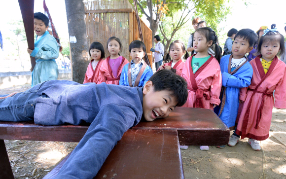 8일 한성백제문화제가 열리고 있는 서울 송파구 올림픽공원을 찾은 어린이들이 체험마을에서 곤장 체험을 하고 있다. 올림픽공원, 몽촌토성, 위례성대로 등에서 열리는 한성백제문화제는 11일까지 계속된다.  이언탁 기자 utl@seoul.co.kr