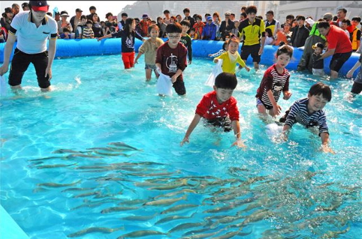 지난해 열린 부산고등어축제에서 어린이들이 대표 체험행사인 ‘맨손으로 고등어 잡기’를 하고 있다. <br>부산시 제공