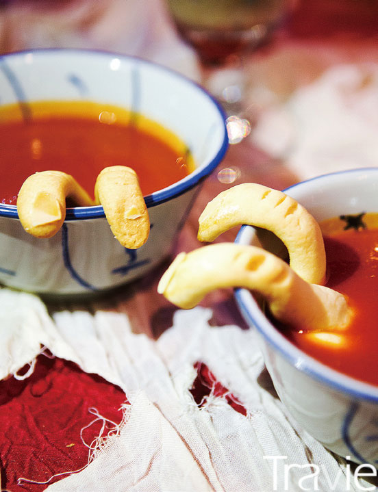 그릇 속에 담긴 손가락 모양 쿠키로 장식한 레몬 그라스 토마토 수프.