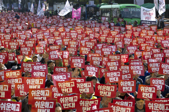 15일 오후 서울 종로구 대학로에서 열린 ‘쉬운해고·평생 비정규직 노동개악 저지 민주노총 공공노동자 파업대회’ 에서 전국공공운수노조원들을 비롯한 민주노총 관계자들이 쉬운해고를 반대하는 글자가 적힌 종이를 들고 있다.  연합뉴스
