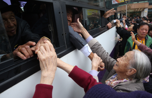 지난해 2월 이후 1년8개월만에 열린 제20차 이산가족 상봉행사 1회차 마지막날인 22일 오전 강원도 고성군 금강산 이산가족면회소에서 작별상봉을 마친 북쪽가족과 남쪽 가족이 북쪽 가족이 먼저 차량에 탑승해 떠나면서 이별을 하고  있다. 북쪽 오인세 할아버지와 이순규 할머니가 손을 잡으며 이별하고 있다. 사진공동취재단