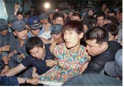 경찰이 1999년 7월 16일 전남 순천시에서 탈옥수 신창원을 검거해 압송하고 있다.  경찰청 제공