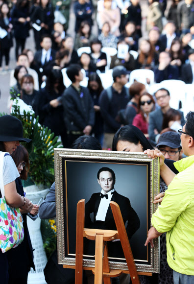 25일 오후 경기도 안성시 유토피아 추모관에서 열린 ‘신해철 1주기 추모식 및 봉안식’에서 팬들이 고인의    영정사진에 남기고 싶은 메시지를 적고 있다. 연합뉴스