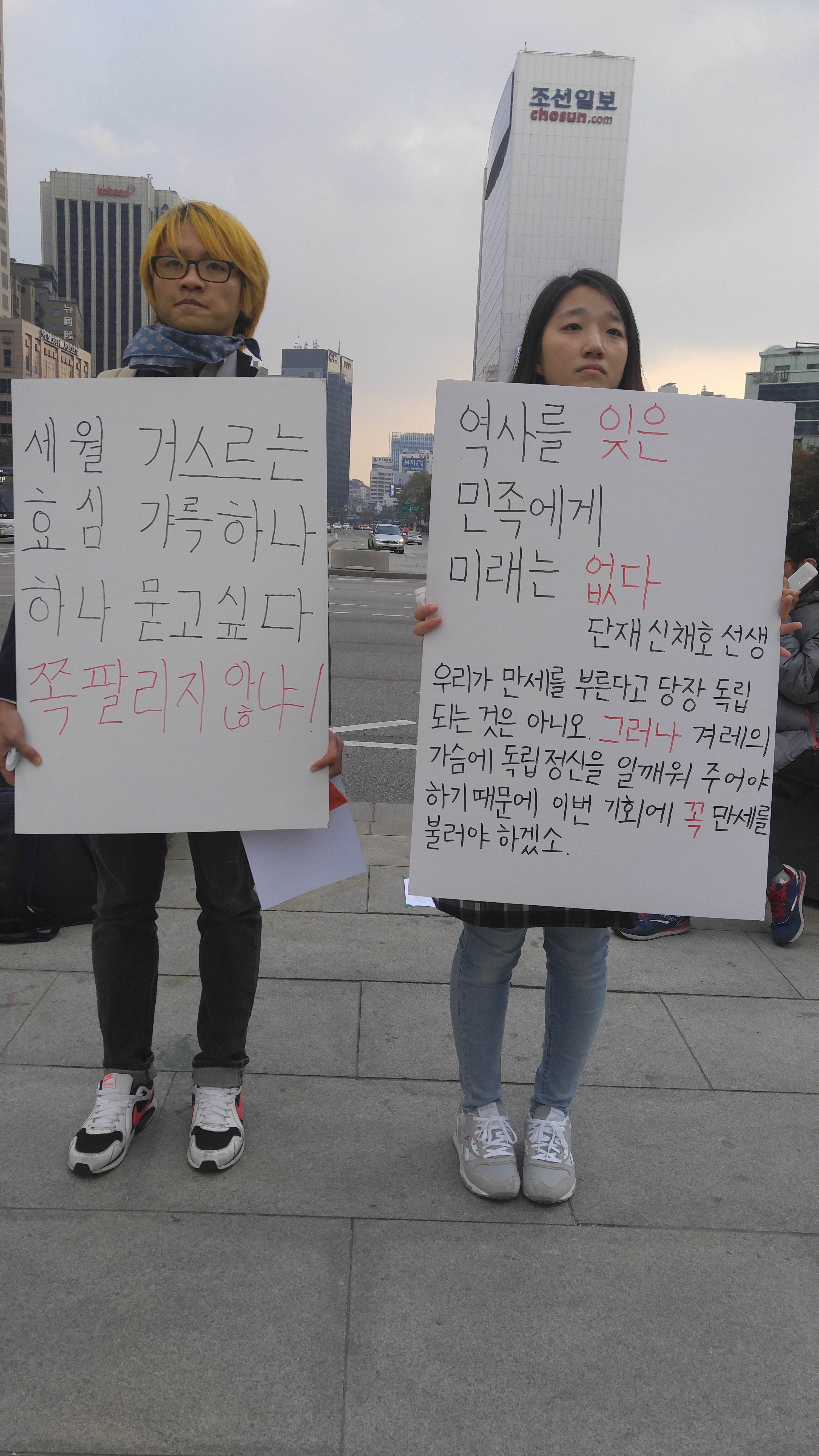 서울 광화문광장에서 경인교대 조성현군과 김민지양이 “역사를 거스른 민족에게 미래는 없다”라는 플래카드를 들고 국정교과서 반대운둥을 벌이고 있다.