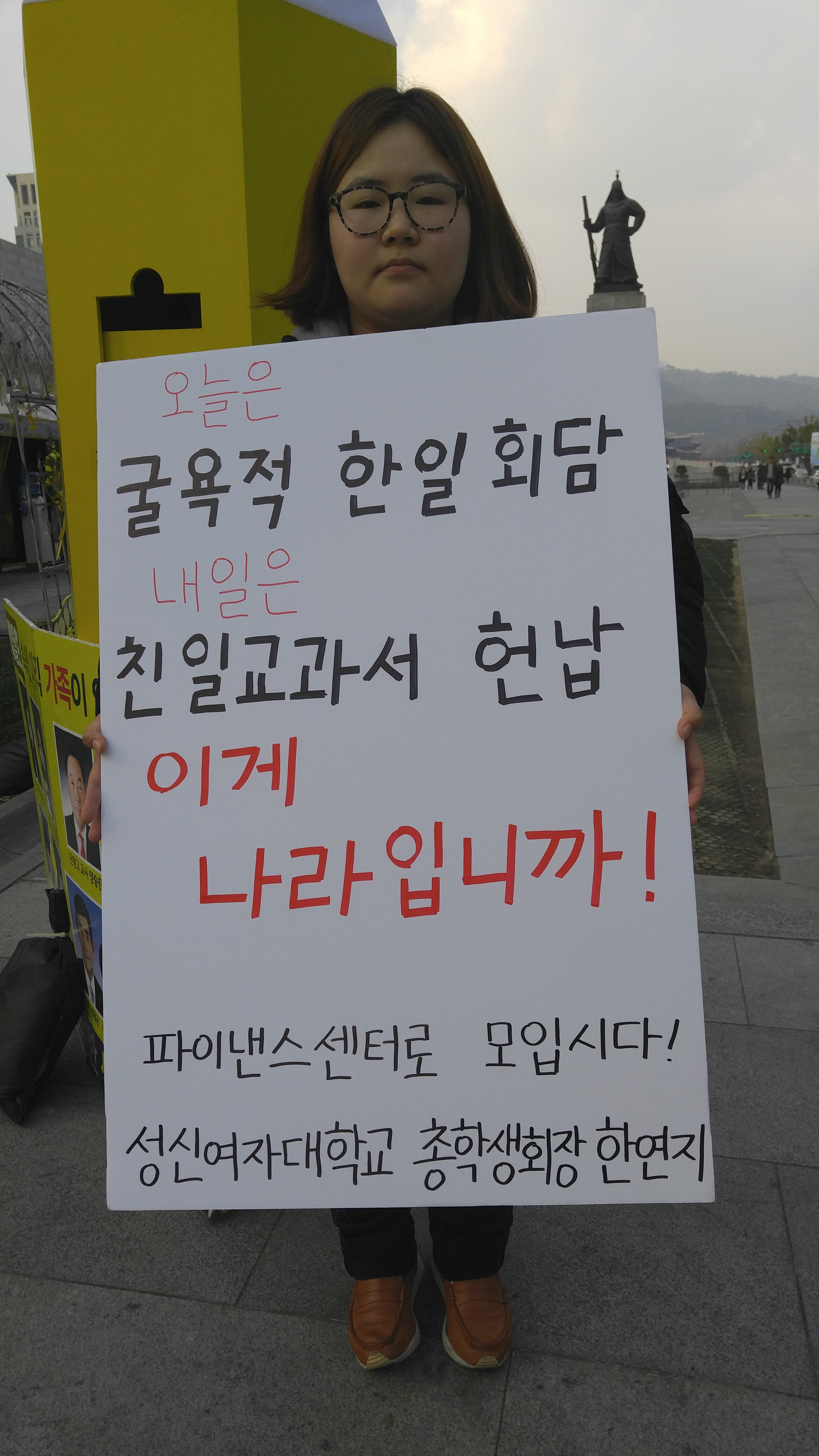 한연지 서울 성신여대 총학생회장이 광화문광장에서 “굴욕적 한일회담과 친일교과서 반납”이라는 플래카드를 들고 14일 전국적인 시위장소인 서울 태평대로 파이낸스센터로 모이자고 1인시위를 하고 있다.