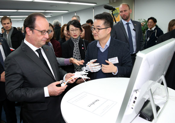 프랑수아 올랑드 프랑스 대통령이 4일 서울 강남구 선릉로에 있는 민간 창업지원 기관인 디캠프(D.CAMP)를 찾아 스마트 재활의료 솔루션 관련 스타트업 관계자로부터 ‘스마트 글러브’에 대한 설명을 듣고 있다.  연합뉴스