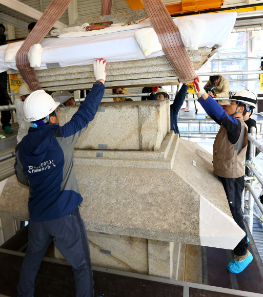 국립문화재연구소 관계자들이 4일 오전 경북 경주시 진현동 불국사 경내에 있는 불국사 삼층석탑(석가탑) 복원 마무리 작업을 하며 3층 옥개석을 올리고 있다.  연합뉴스