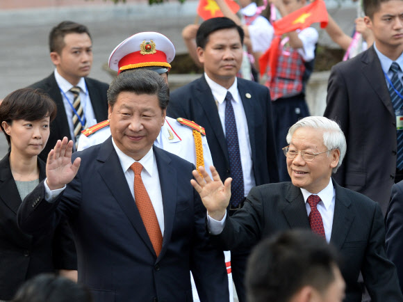 시진핑은 남중국해 설득 위해 베트남으로… 5일부터 이틀 일정으로 베트남을 국빈 방문한 시진핑(왼쪽) 중국 국가주석이 하노이 대통령궁에서 열린 환영 행사 뒤 응우옌푸쫑 베트남 서기장과 나란히 걸으며 손을 흔들고 있다. 하노이 AP 연합뉴스