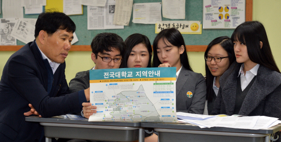 13일 오전 서울 서초고등학교에서 전날 대학수학능력시험을 치른 학생들이 교사와 함께 정시모집 배치 참고표를 들여다보며 얘기를 나누고 있다. 박지환 기자 popocar@seoul.co.kr