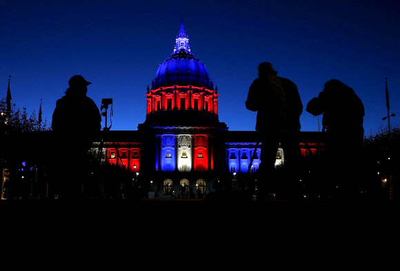 미국 캘리포니아주 샌프란시스코 시청은 14일(현지시간) 프랑스 파리 테러 희생자를 애도하는 의미로 프랑스 국기를 상징하는 파란색, 흰색, 붉은색 조명을 비추고 있다. 금요일 프랑스 수도에 테러리스트들의 공격으로 적어도 129명이 사망하고 300명 이상의 부상자가 발생했다. ⓒ AFPBBNews=News1