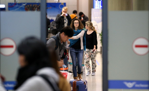 프랑스 파리에서 일어난 테러로 인천국제공항에 대테러 대비 경계·경비가 강화된 16일 인천 영종도 인천공항에서 프랑스 파리발 항공기에 탑승한 승객들이 입국장을 빠져나오고 있다.  연합뉴스