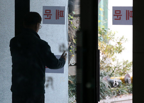 한상균 민주노총 위원장이 서울 종로구 조계사에 은신한 가운데 20일 오전 조계사 관계사가 한 위원장이 머물고 있는 건물 출입구에 폐문 문구를 붙이고 있다. 연합뉴스