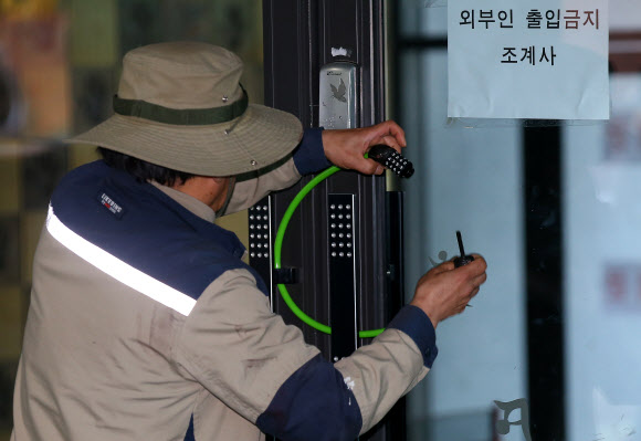 20일 오후 민주노총 한상균 위원장이 피신한 것으로 알려진 서울 종로구 조계사 관음전에서 한 관계자가 1층 출입문을 폐쇄하고 있다.  연합뉴스