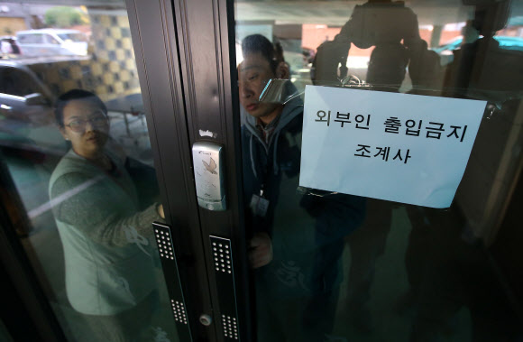 20일 오후 민주노총 한상균 위원장이 피신해 있는 서울 종로구 조계사 관음전에서 조계사 관계자들이 센서가 고장난 출입문을 살펴보고 있다. 연합뉴스