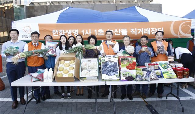 차남규(오른쪽 네 번째) 한화생명 사장과 임직원들이 지난 9월 서울 여의도 63빌딩 앞마당에서‘농산물 직거래장터’를 열어 우리 농산물을 소개하고 있다. 한화생명 제공