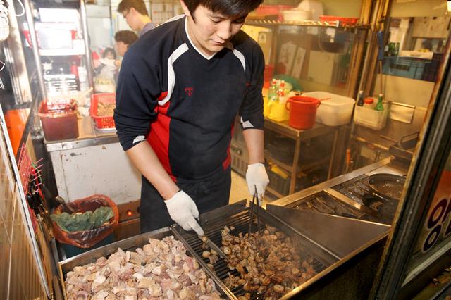 서울 성동구 ‘왕십리 곱창골목’의 한 가게에서 직원이 곱창을 굽고 있다.