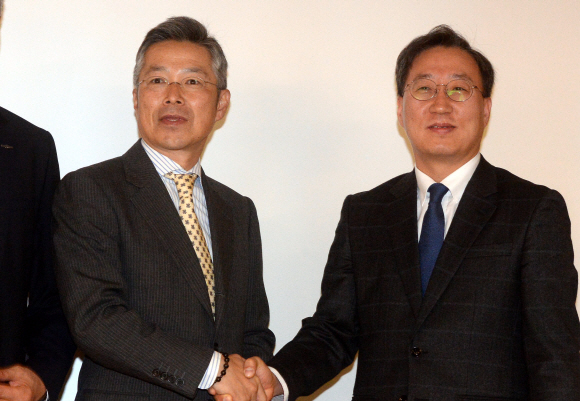 국내 첫 인터넷전문은행 사업자에 대한 예비인가 심사 결과 선정된 한국카카오은행 컨소시엄의 윤호영 카카오 모바일은행 TF 부사장(오른쪽)과 케이뱅크 컨소시엄의 김인회 단장이 30일 서울 중구 은행회관에서 사업계획을 설명하기에 앞서 악수를 하고 있다.  이종원 선임기자 jongwon@seoul.co.kr