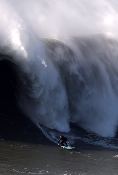 포르투갈 알렉스 보텔류 빅 웨이브 서퍼가 29일(현지시간) 포르투갈 레이리아주 나자레 프라이아 두 노르치(Praia do Norte)에서 서프 세션 진행 중 밀려오는 거대한 파도를 타고 있다. ⓒ AFPBBNews=News1