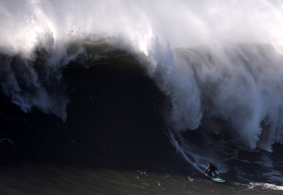 포르투갈 알렉스 보텔류 빅 웨이브 서퍼가 29일(현지시간) 포르투갈 레이리아주 나자레 프라이아 두 노르치(Praia do Norte)에서 서프 세션 진행 중 밀려오는 거대한 파도를 타고 있다. ⓒ AFPBBNews=News1