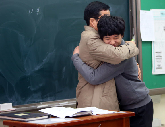 2016학년도 수능시험 성적표 를 배부한 2일 대전 둔원고등학교 한 교사가 성적표를 나눠주기 앞서 학생을 꼭 안아주고 있다. 연합뉴스