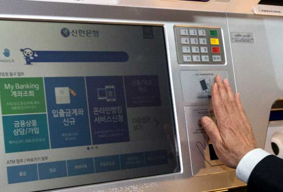 2일 서울 중구 신한은행 본점에서 열린 모바일 전문은행 ‘써니뱅크’와 무인스마트점포 ‘디지털키오스크’ 출시 행사에서 임종룡 금융위원장이 디지털키오스크에 손바닥정맥 인식을 통해 본인을 인증하는 비대면 실명확인을 시연해보고 있다.  신한은행은 ‘비대면 실명확인’으로 은행에 가지 않고 계좌개설 등 은행 업무가 가능한 모바일 전문은행 ‘써니뱅크(Sunny Bank)’와 일반창구 수준의 업무를 이용할 수 있는 무인스마트점포 ‘디지털 키오스크’를 2일부터 시행한다고 밝혔다.  연합뉴스