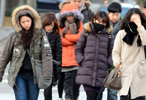 기온이 영하로 떨어진 4일 광화문 사거리 횡단보도에서 시민들이 두터운 겉옷과 목도리로 몸을 감싸고 출근길을 서두르고 있다. 강성남 선임기자 snk@seoul.co.kr