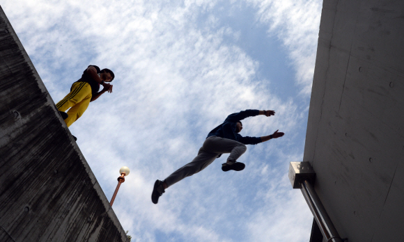 건너편 건물로 뛰어넘기 위해 점프한 학생이 마치 하늘을 나는 것처럼 보인다.
