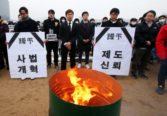 10일 오후 경기도 과천시 정부과천청사에서 열린 ‘제2차 전국 로스쿨 법무부 규탄대회’에서 참석한 로스쿨 학생들이 변호사시험 응시표를 불태우고 있다.  연합뉴스