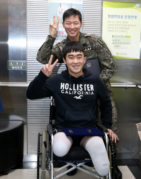  지난 8월 비무장지대(DMZ)에서 북한의 지뢰 도발로 다리를 잃은 김정원 하사(뒤)와 하재헌 하사가 14일 오후 서울 강동구 둔촌동 중앙보훈병원에서 태광그룹과 에스오일로부터 장학증서를 받은 뒤 활짝 웃으며 행사장을 나서고 있다. 두 기업은 이들이 국내에서 학위 취득을 원할 경우 석·박사까지 진학 비용 일체를 지원하기로 했다.   연합뉴스