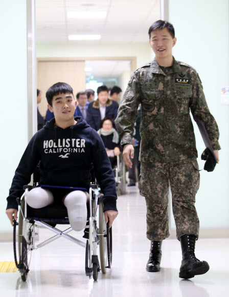 지난 8월 비무장지대(DMZ)에서 북한의 지뢰 도발로 다리를 잃은 김정원 하사(오른쪽)와 하재헌 하사가 14일 오후 서울 강동구 둔촌동 중앙보훈병원에서 태광그룹과 에스오일로부터 장학증서를 받은 뒤 행사장을 나서고 있다. 두 기업은 이들이 국내에서 학위 취득을 원할 경우 석·박사까지 진학 비용 일체를 지원하기로 했다.  연합뉴스