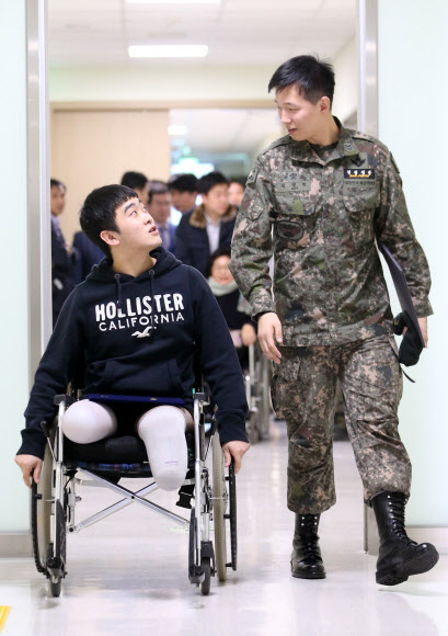 지난 8월 비무장지대(DMZ)에서 북한의 지뢰 도발로 다리를 잃은 김정원 하사(오른쪽)와 하재헌 하사가 14일 오후 서울 강동구 둔촌동 중앙보훈병원에서 태광그룹과 에스오일로부터 장학증서를 받은 뒤 행사장을 나서고 있다. 두 기업은 이들이 국내에서 학위 취득을 원할 경우 석·박사까지 진학 비용 일체를 지원하기로 했다.   연합뉴스