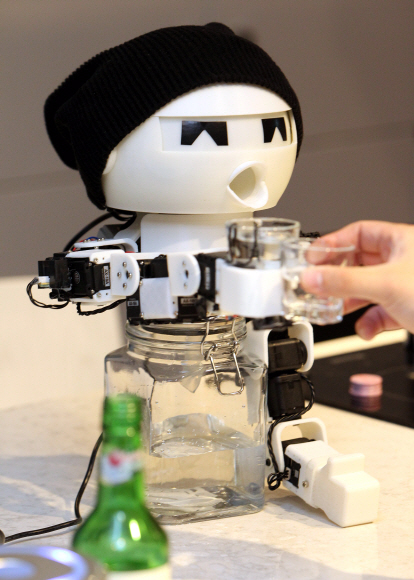 16일 서울 중구 타작마당에서 열린 ’로봇파티’를 찾은 관람객들이 함께 술을 마셔주는 로봇인 ’드링키’와 함께 술잔을 기울이고 있다. 이종원 선임기자 jongwon@seoul.co.kr