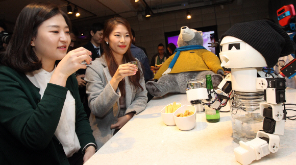 16일 서울 중구 타작마당에서 열린 ’로봇파티’를 찾은 관람객들이 함께 술을 마셔주는 로봇인 ’드링키’와 함께 술잔을 기울이고 있다. 이종원 선임기자 jongwon@seoul.co.kr