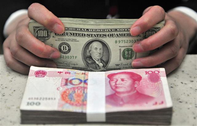 중국 동북부 셴양의 화샤 은행 직원이 미국 달러와 중국 위안화를 세고 있다. EPA 연합뉴스