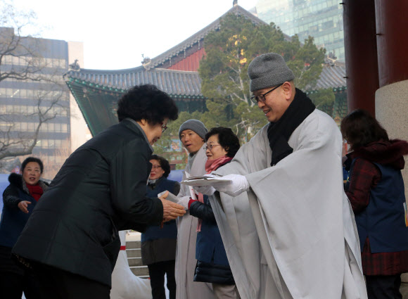 22일 서울 종로구 조계사에서 열린 동지헌말 행사에서 스님들이 양말을 나눠주고 있다. 동지헌말은 해가 길어지기 시작하는 동지에 집안의 어르신들에게 버선을 지어 드리며 무병장수를 기원하는 풍습에서 유래했다.  연합뉴스