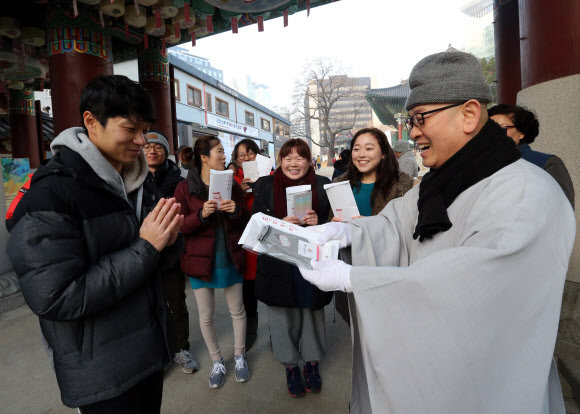 22일 서울 종로구 조계사에서 열린 동지헌말 행사에서 스님들이 양말을 나눠주고 있다. 동지헌말은 해가 길어지기 시작하는 동지에 집안의 어르신들에게 버선을 지어 드리며 무병장수를 기원하는 풍습에서 유래했다.  연합뉴스