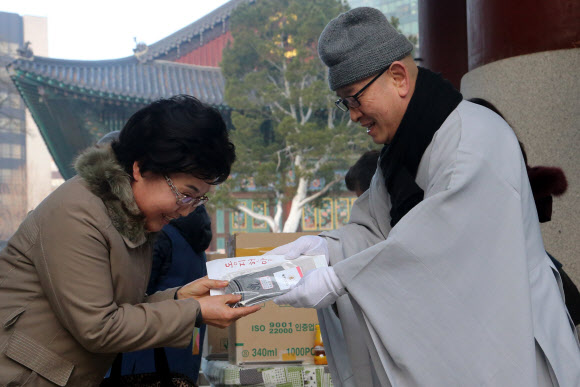 22일 서울 종로구 조계사에서 열린 동지헌말 행사에서 스님들이 양말을 나눠주고 있다. 동지헌말은 해가 길어지기 시작하는 동지에 집안의 어르신들에게 버선을 지어 드리며 무병장수를 기원하는 풍습에서 유래했다.  연합뉴스
