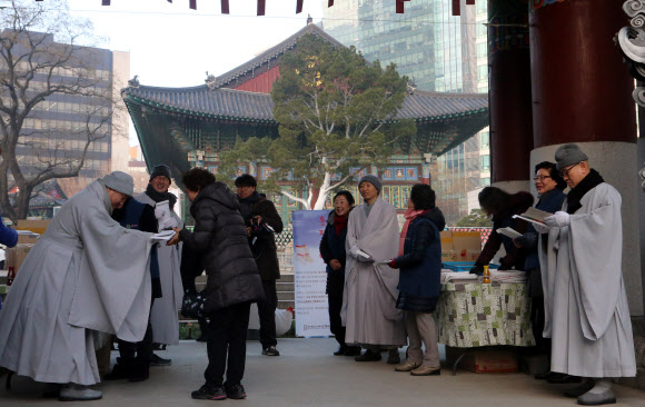 22일 서울 종로구 조계사에서 열린 동지헌말 행사에서 스님들이 양말을 나눠주고 있다. 동지헌말은 해가 길어지기 시작하는 동지에 집안의 어르신들에게 버선을 지어 드리며 무병장수를 기원하는 풍습에서 유래했다.  연합뉴스