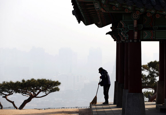 수도권 지역 미세먼지 농도기 ‘나쁨’으로 예보된 22일 오전 경기도 수원시 화성(華城) 서장대에서 관리인이 빗자루질을 하고 있다.  연합뉴스