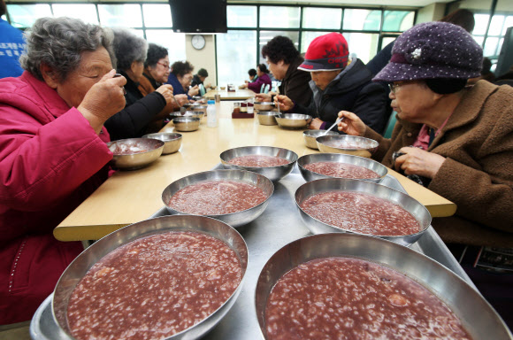 22일 오전 경기도 수원시 권선구 서호노인복지관에서 열린 동지(冬至) 팥죽 나누기 행사에서 어르신들이 팥죽을 먹고 있다.  연합뉴스